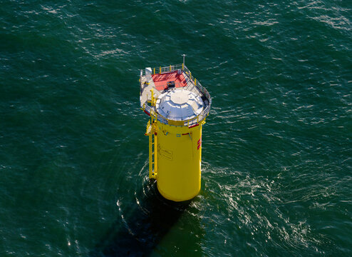 Base of incomplete wind turbine in sea on sunny day