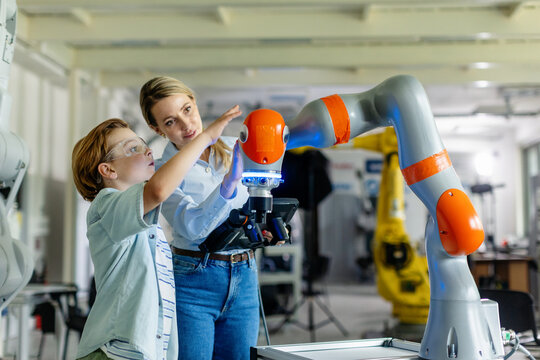 Mom and boy during take your kid to work day, encouraging children in career in robotics. Field trip to real robotics laboratory. Real scientist talking with schoolboy. - Powered by Adobe