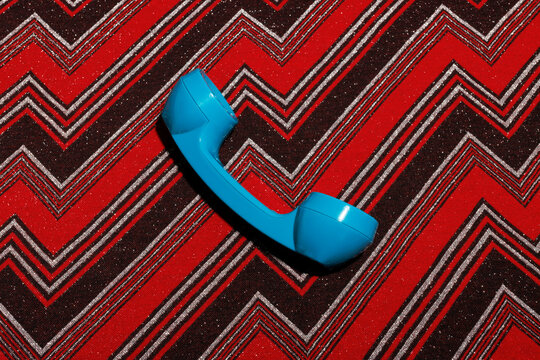 Telephone receiver kept over patterned background