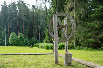 The old wooden wheel on the axle hangs at the top on two poles. Installation in nature was made by...