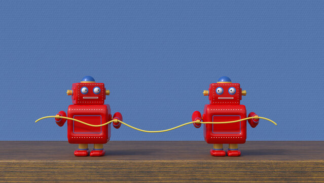 Small red robots with cable on table in front of blue textured wall