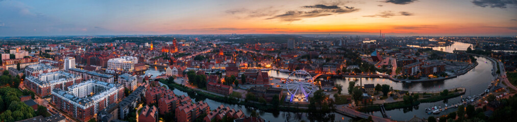 Panorama of the Main Town of Gdansk with illuminated ferris wheel at sunset, Poland.