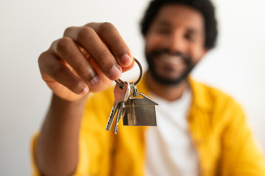Happy young man holding keys of new house