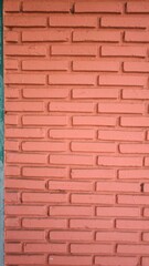 The wall is made of orange bricks.