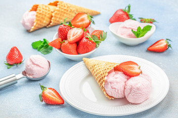 Strawberry ice cream scoop with fresh strawberries and icecream cones