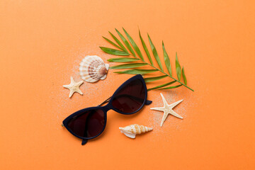 sunglasses with seashell lying on table background. Sunglasses on summer background. Top view flat...