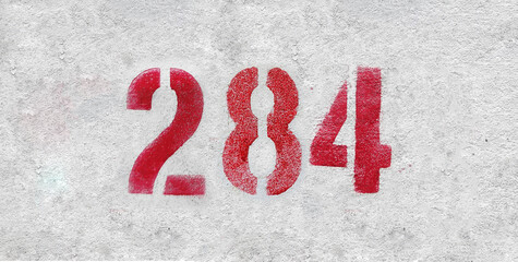 Red Number 284 on the white wall. Spray paint.