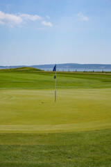 Obraz premium scenic golf course hole with green and flag. golf course landscape on sunny day. sport and leisure 