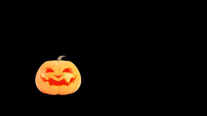 Halloween pumpkin smiles on black background with copy space. Funny Jack o lantern Halloween background.
