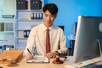 Fototapeta premium Serious pensive lawyer working overtime at desk in office.