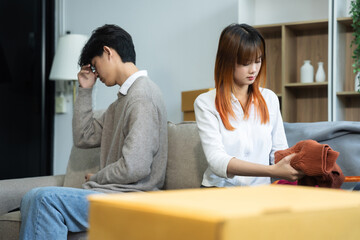 Unhappy young couple sitting apart, having problems in relationship, thinking of breaking up or divorce, upset, family lovers, man and woman avoid talking in relationship problems.