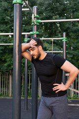 Obraz premium Young athletic man gets very tired while working out outdoors