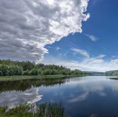 A calm lake with a cloudy sky in the background
