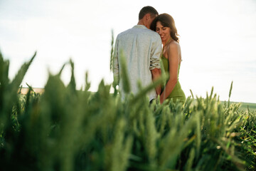 Under the sunlight, enjoying each other. Lovely couple are on the agricultural field together