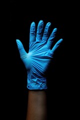 A close-up shot of a person's hand wearing a blue glove, great for use in various scenarios where a subtle touch is needed