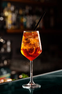 Close up of cold drink in a dark night bar, italian aperol spritz, wine-based cocktail, consists of Prosecco wine, digestive bitters, soda water and oranges.