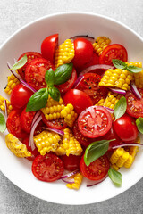 Tomato and corn salad with fresh basil, onion, dressed with olive oil. Mexican food, tomato corn salad Esquites, top view