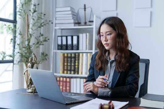 A female attorney is diligently working at her desk in the office.