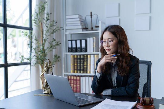 A female attorney is diligently working at her desk in the office.