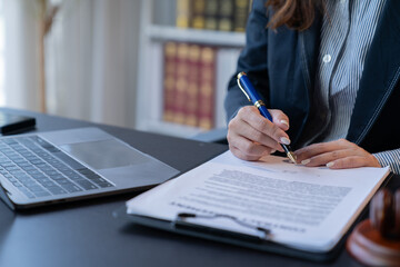 A female attorney is diligently working at her desk in the office.