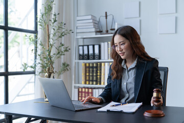 A female attorney is diligently working at her desk in the office.