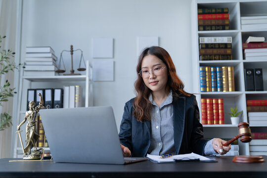 A female attorney is diligently working at her desk in the office.