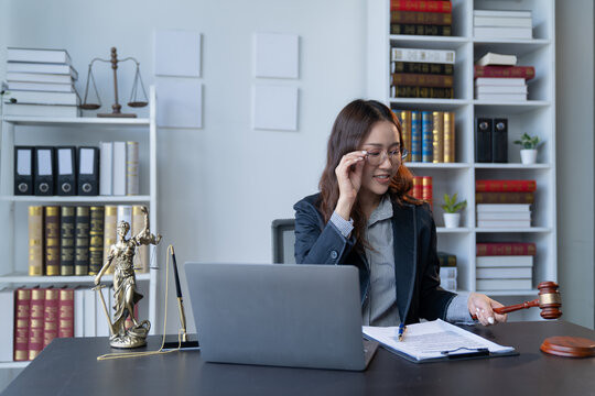 A female attorney is diligently working at her desk in the office.