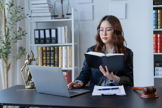 A female attorney is diligently working at her desk in the office.