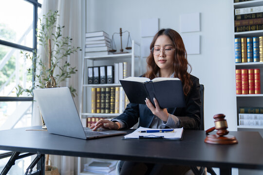 A female attorney is diligently working at her desk in the office.