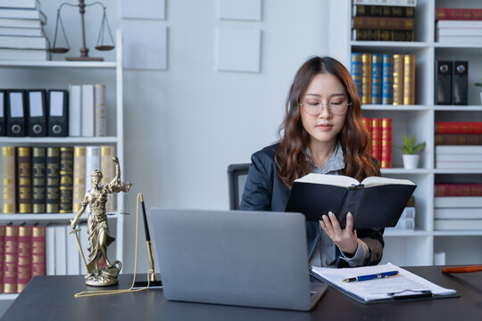 A female attorney is diligently working at her desk in the office.