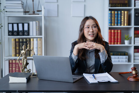 A female attorney is diligently working at her desk in the office.
