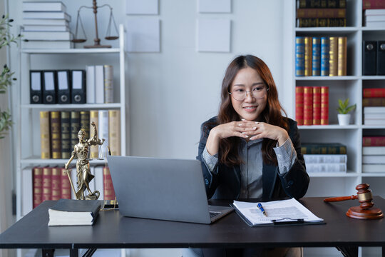 A female attorney is diligently working at her desk in the office.