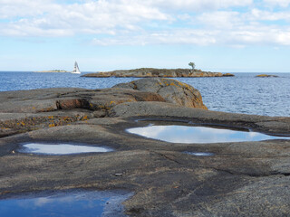 Blick auf die Schären in der Nähe von Stockholm in Schweden von Felsen aus die mit Wasser...
