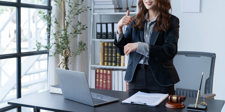 A female attorney is diligently working at her desk in the office.