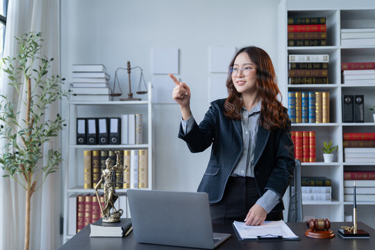 A female attorney is diligently working at her desk in the office.