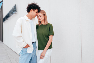 Smiling beautiful woman and her handsome boyfriend. Couple in casual summer clothes. Happy cheerful family. Female and man having fun. They posing in the street in sunny day. Having tender moments