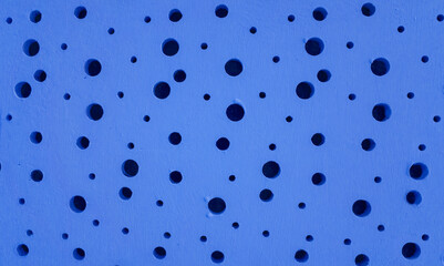 A surface made of cement plaster, with the texture of a plaster wall, in a light deep dark blue color, with round holes of different sizes, is also used for wrapping three-dimensional models