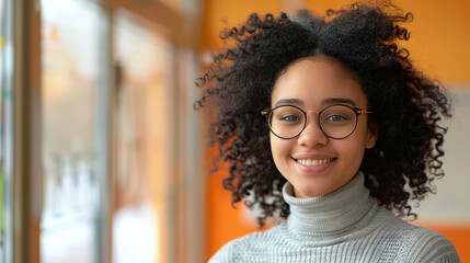 Obraz premium Young smiling woman teacher in glasses and sweater in school