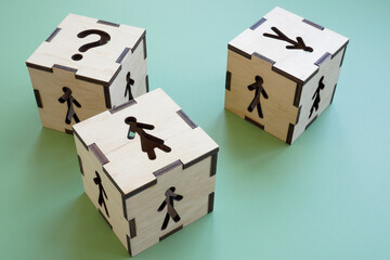 Obraz premium Cubes with figures of a woman, a man and question mark. Gender equality in employment and career.