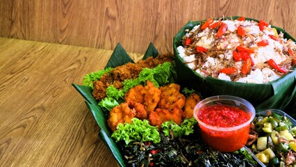 Nasi liwet is a typical Indonesian rice dish cooked with coconut milk, chicken stock and spices, giving the rice a rich, aromatic and savory taste.served on wooden basket