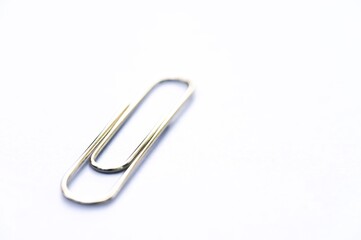 Metal clip. Minimalism office paper clip for important documents and files. White background, isolation.