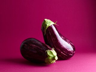 ripe eggplants over magenta background