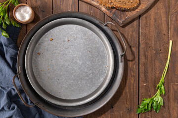Empty metal plate on a brown rustic background. Top view.