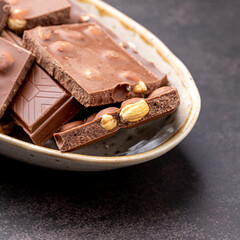 Chocolate cupcake with icing and chocolate bar in Dark lighting,Homemade delicious chocolate muffin on wooden background close-up