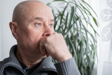 Elderly man with serious expression looking to side, burdened by life's worries, furrowed brow