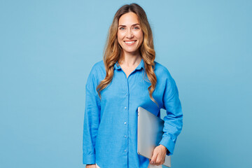 Young smiling happy cheerful IT woman wear shirt casual clothes hold closed laptop pc computer...