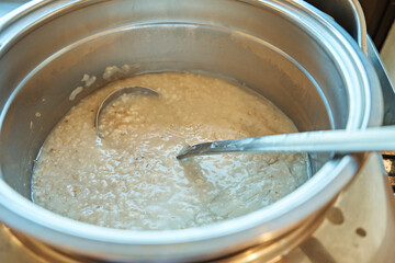 Oatmeal in a deep saucepan with a ladle. Self-service restaurant. Diet and healthy food. Healthy breakfast. Selective focus