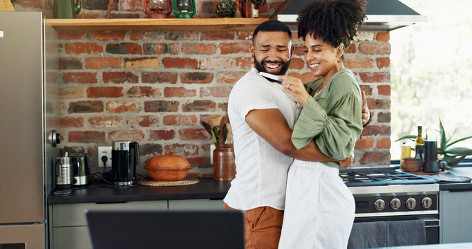 Couple, happy and hug for pregnancy test in home with announcement, celebration and ivf success in kitchen. People, pregnant results and excited for fertility with surprise, embrace and testing kit