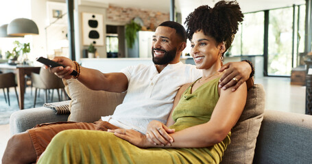 Couple, relax and remote on couch for movie with embrace, watching tv and streaming service in...