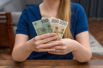 Kobieta trzyma w rękach tradycyjne papierowe pieniądze 